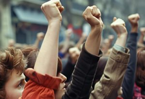 Stock photo of demonstrators raise their fists during a rally in paris, in the style of contemporary vintage photography, women designers, hasselblad 500cm, flickr, soviet, youthful, myportfolio, --ar 3:2 --style raw --stylize 50